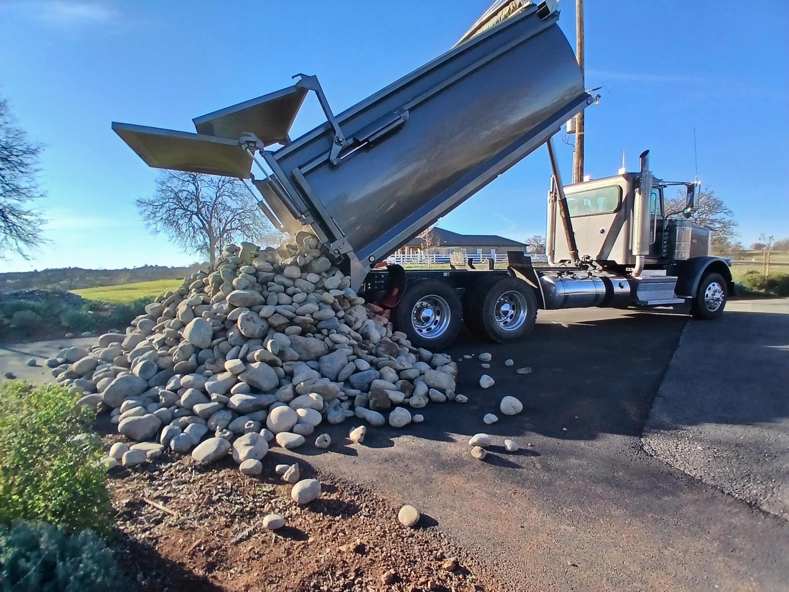 Dump truck delivering gravel for landscaping job