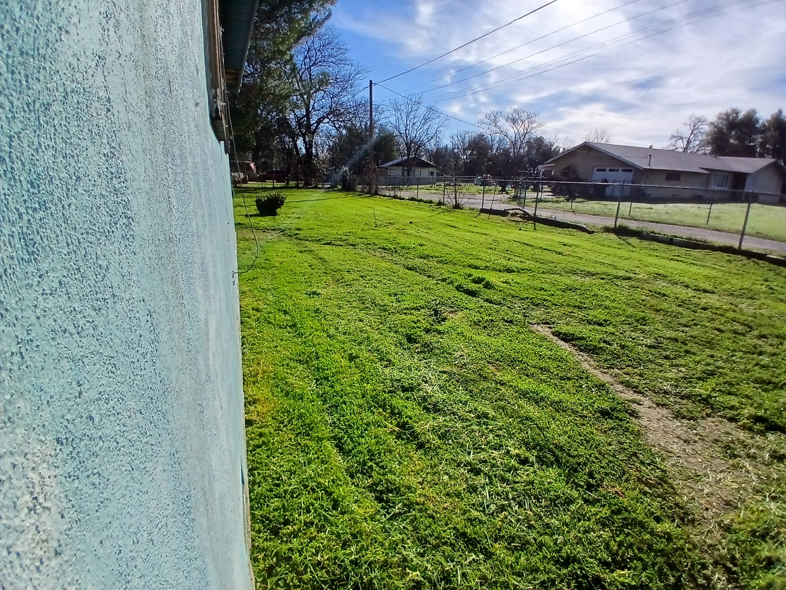 Mowed field along chain-link fence after service